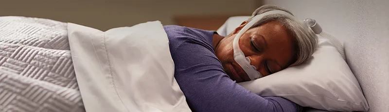 femme dort avec Masque narinaire Philips DreamWear