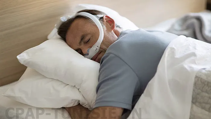 homme dort sur le ventre avec Masque narinaire Philips DreamWear